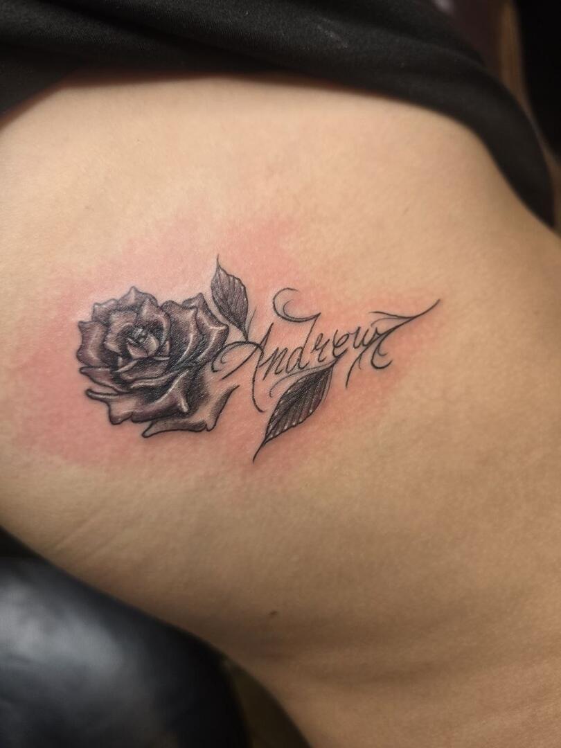 Fine-line rose with script lettering tattoo